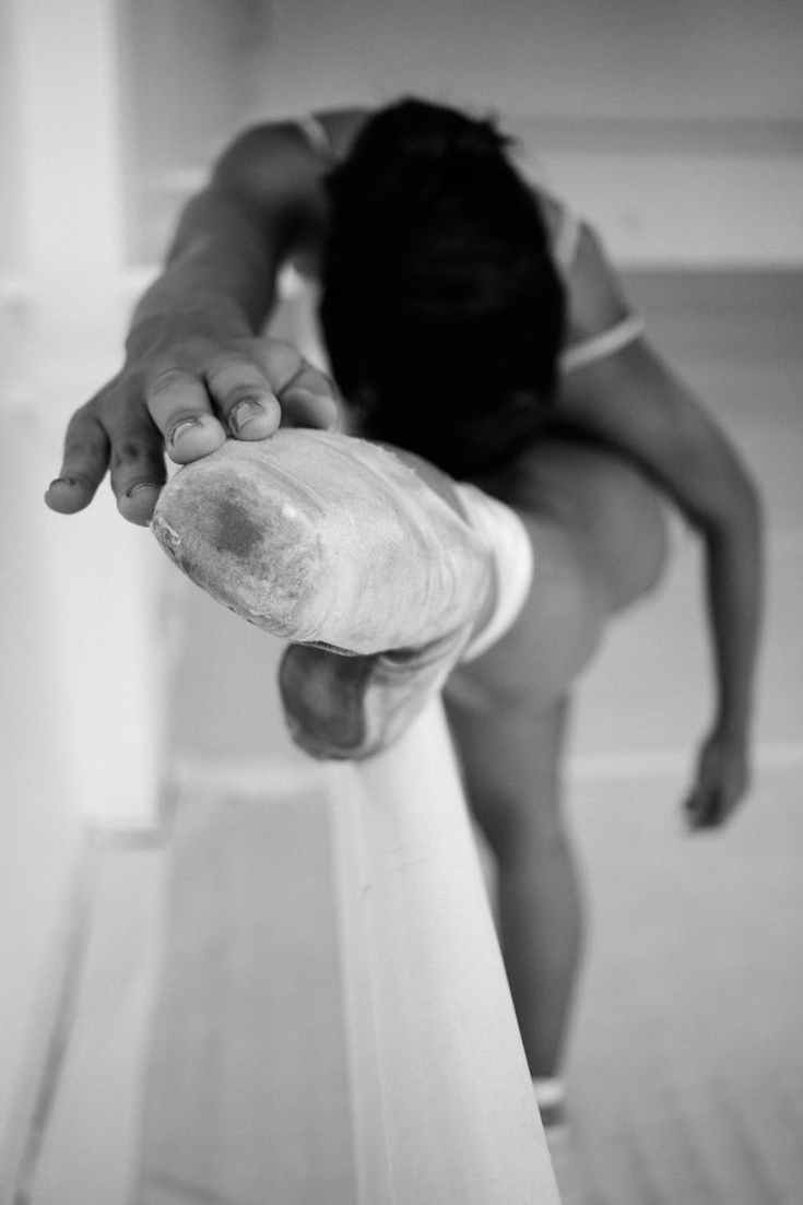 monochrome photo of woman stretching her leg